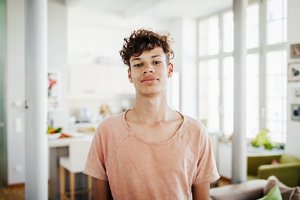 Man with type 3B curly hair wearing a pink t-shirt